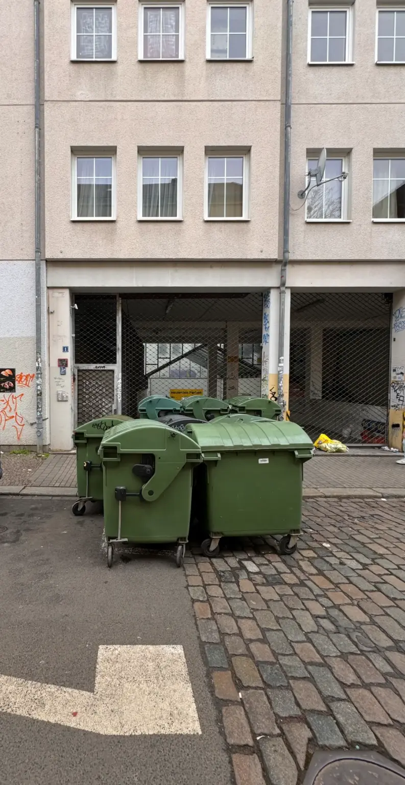 Mülltonnenbereitstellungen: Grüne Mülltonnen vor einem Haus