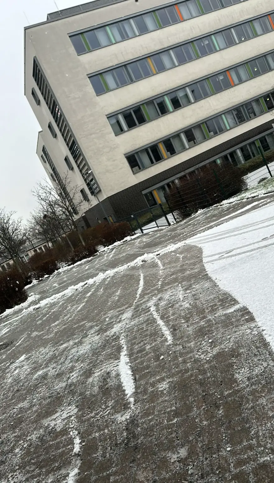 Winterdienst: geräumte Fläche vor einem Bürogebäude